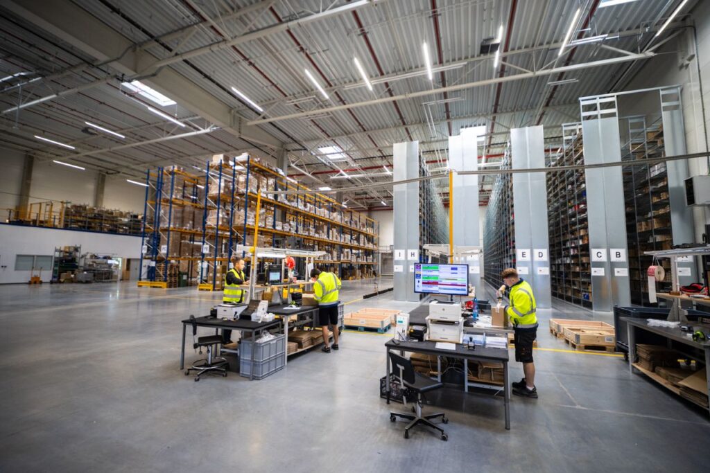 Industrial warehouse with workers organizing and managing inventory.